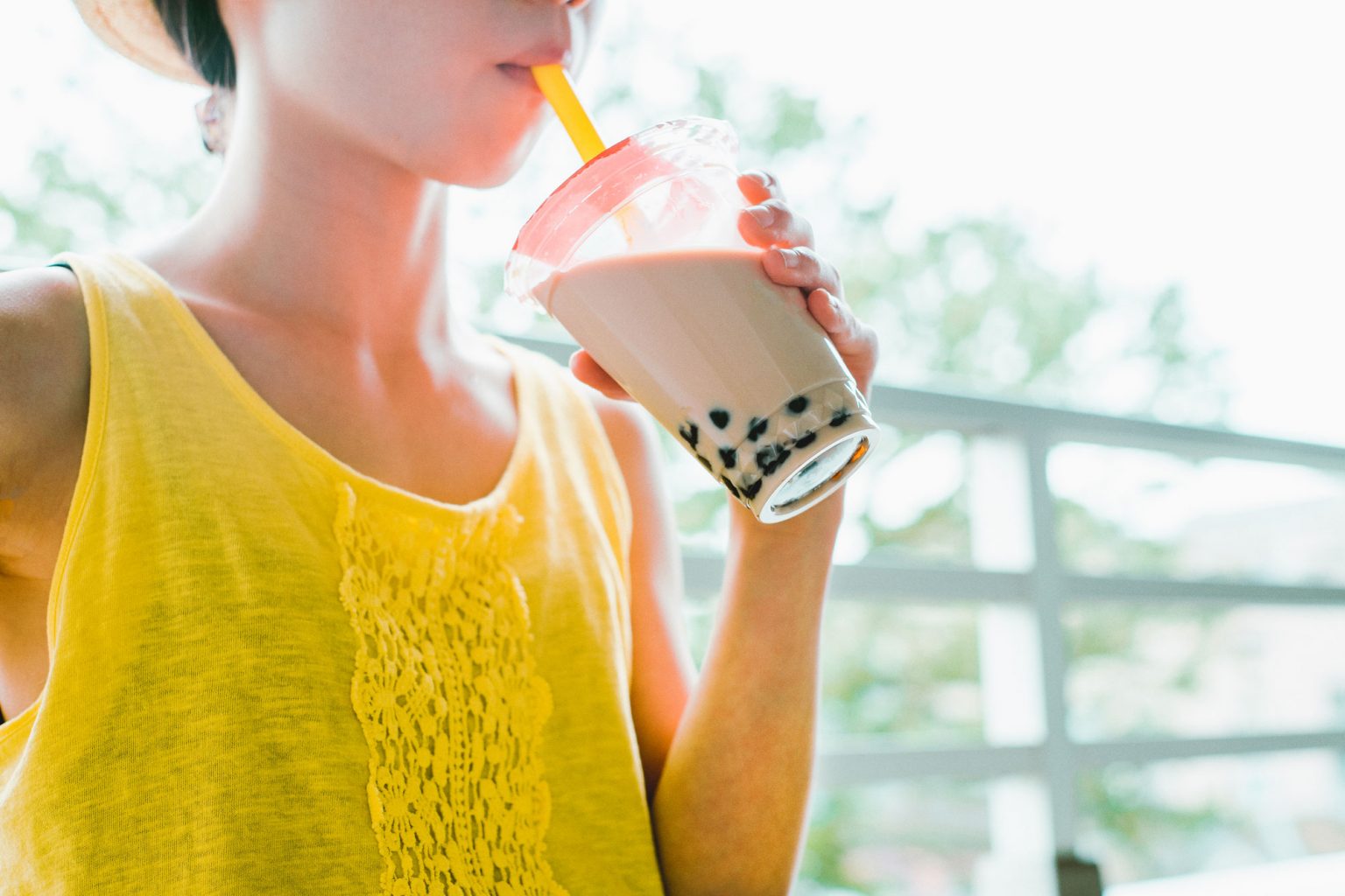 A person happily drinking boba tea.