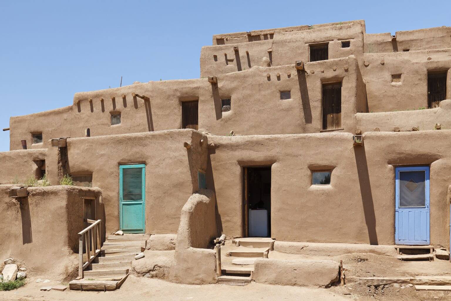 Historic adobe households engulfed bright in sunlight.