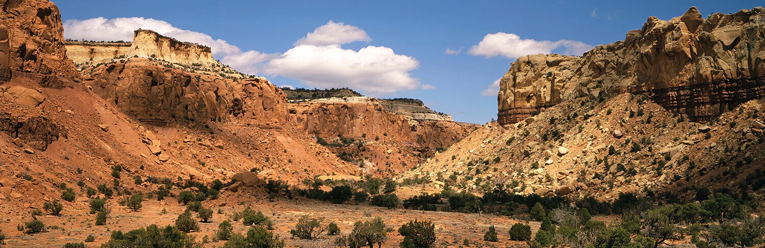 Santa Fe's red rock formations under a sunny, blue sky.