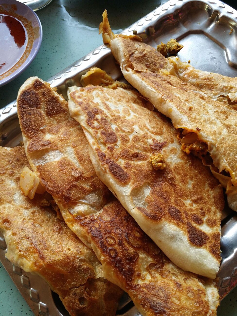A silver plate filled with Roti Prata.