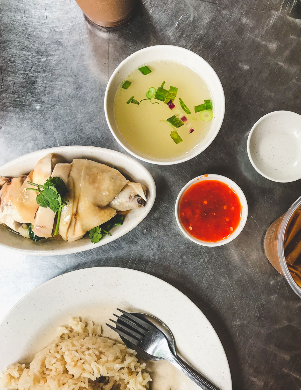 A variety of Singaporean dishes resting on a large, metal table.