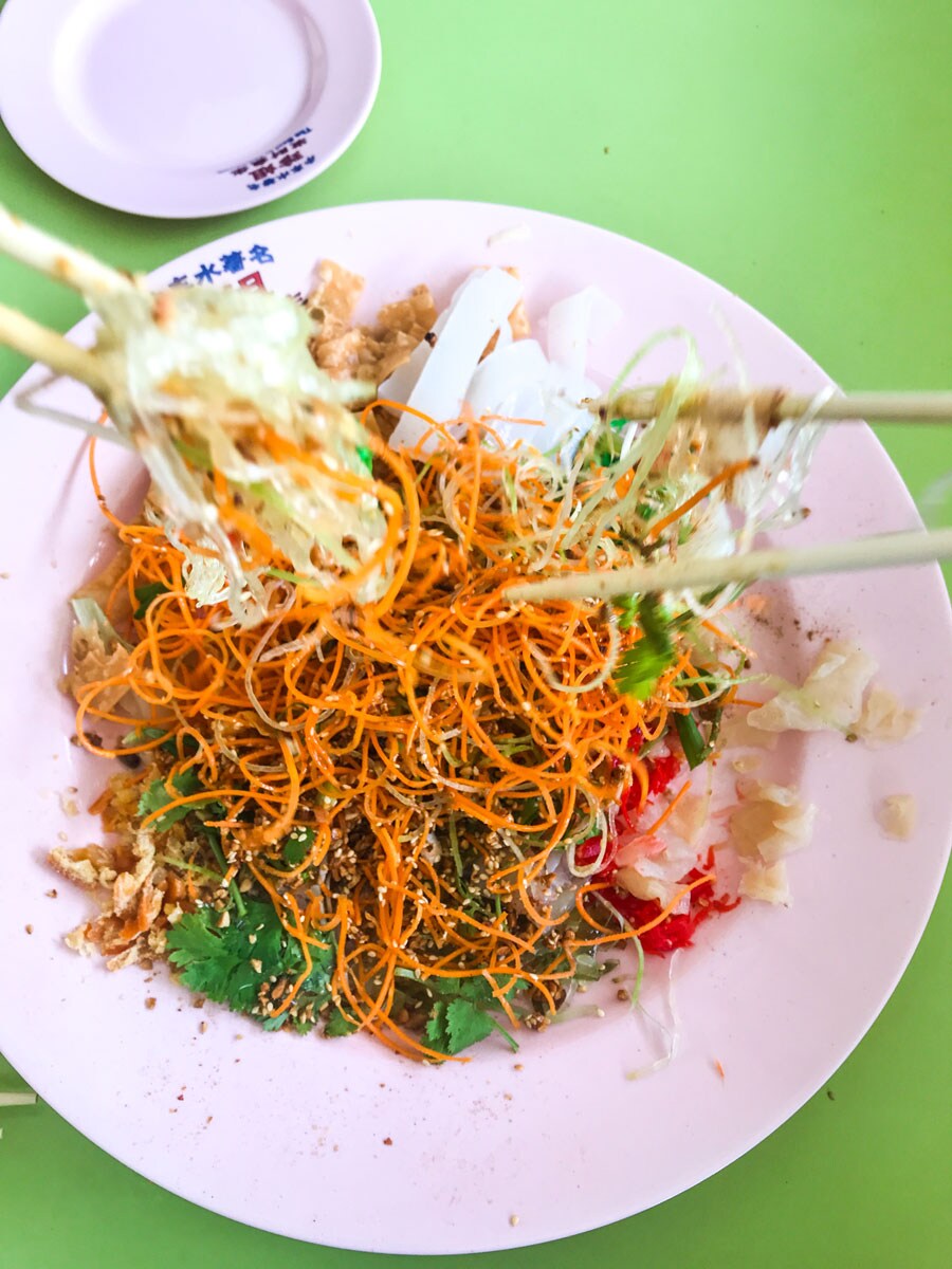 Mixing raw fish salad with chopsticks.