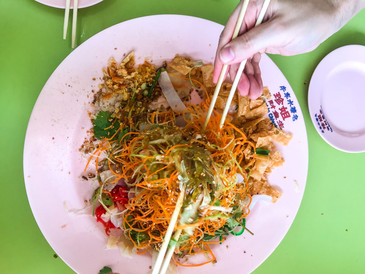 Someone eating raw fish salad with chopsticks.