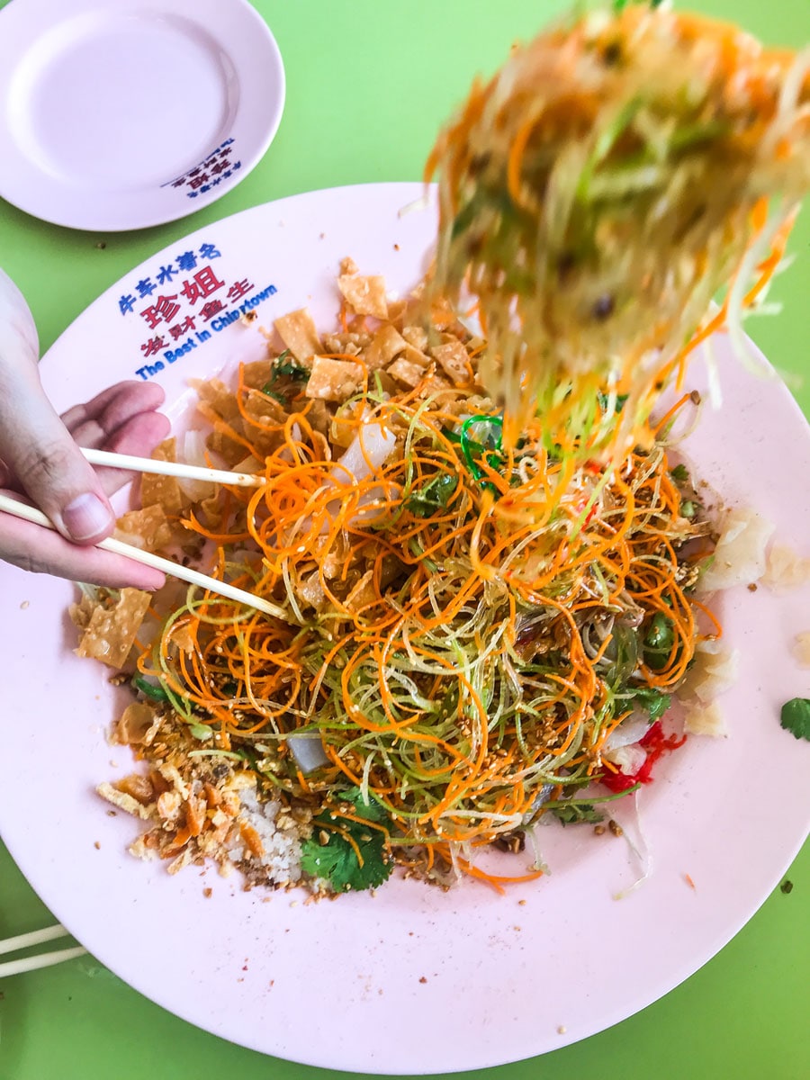 Adding ingredients to yusheng.