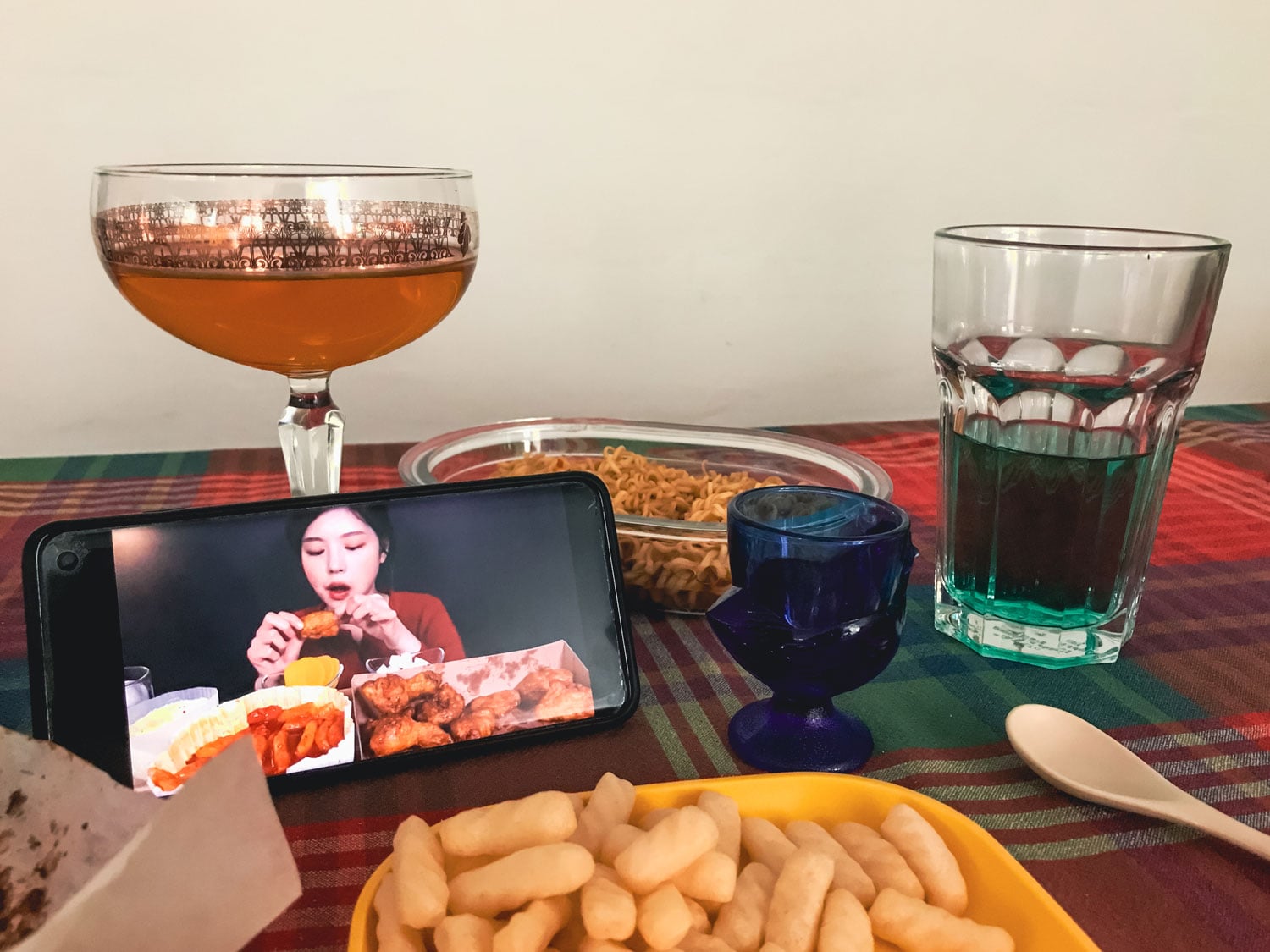 Food for one and a smart phone displaying a person eating.