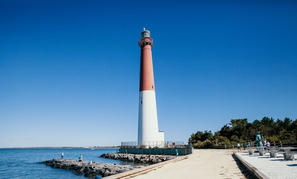 A bold lighthouse resting under a clear blue sky.
