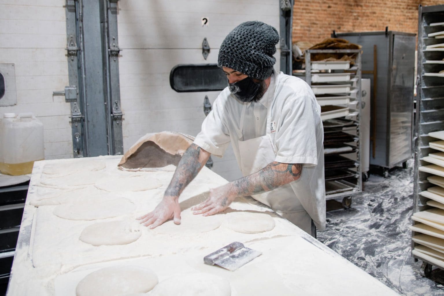 A person pressing against mounds of dough.