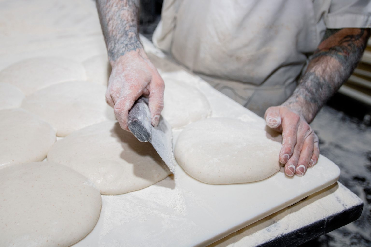 A person gently shaping dough.