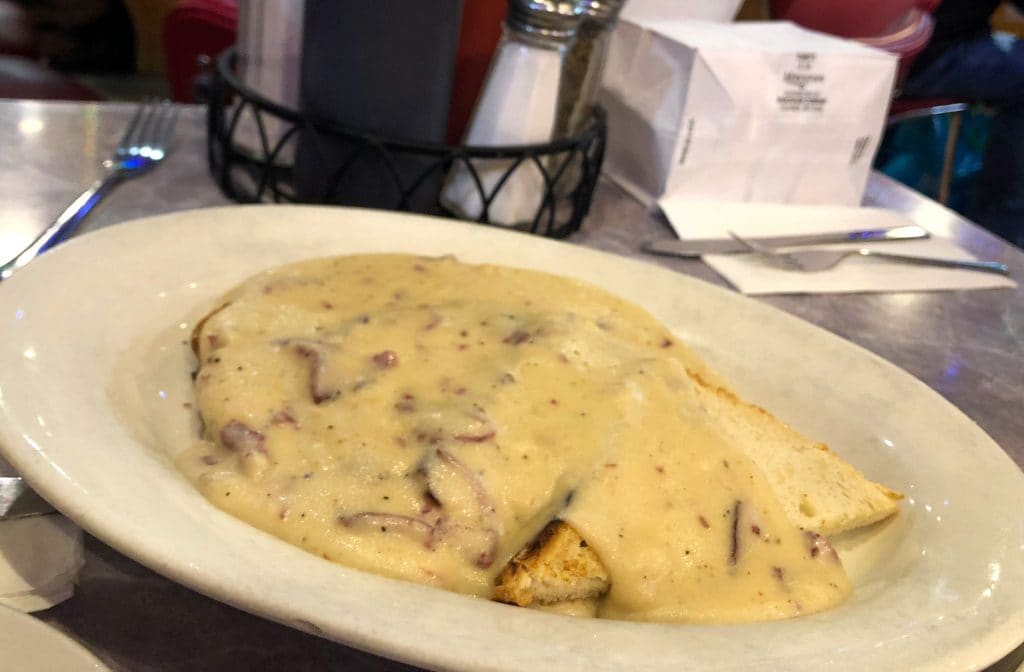 A large white dish of chipped beef topped with creamy white sauce.