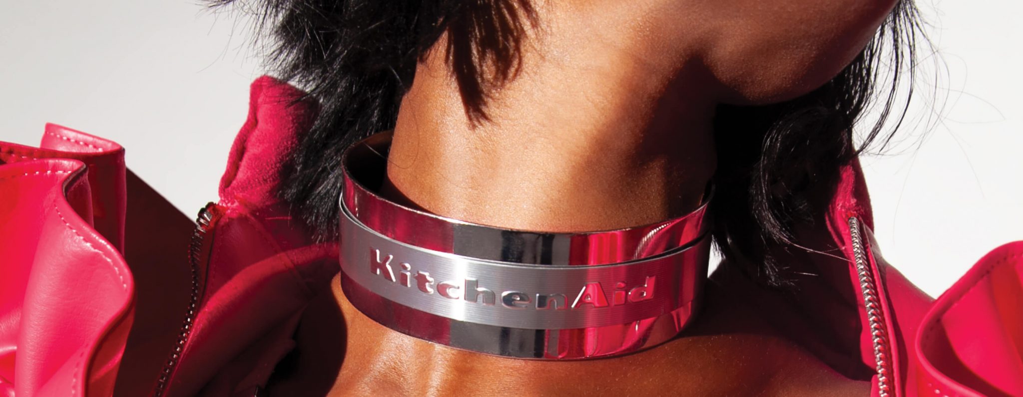A close up of the KitchenAid® logo on the choker necklace of a model.