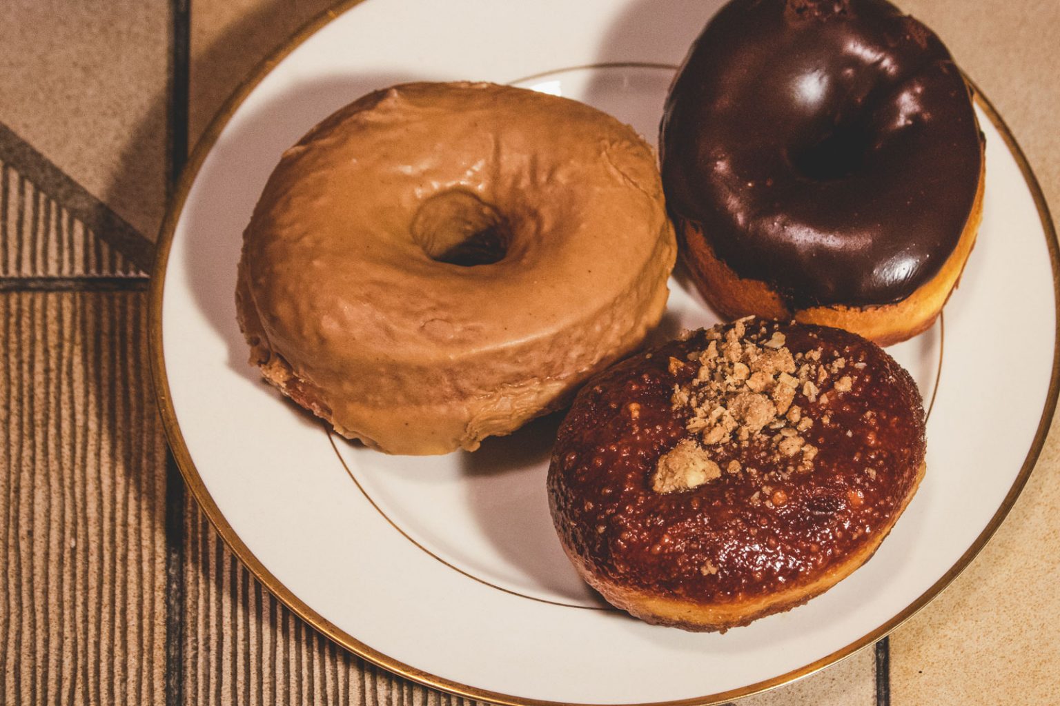 Donuts resting on a white plate.
