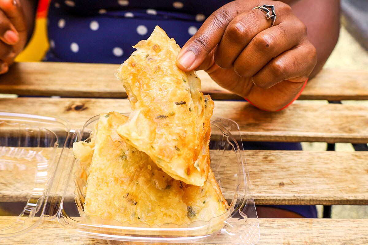 A person holding food from a clear container.
