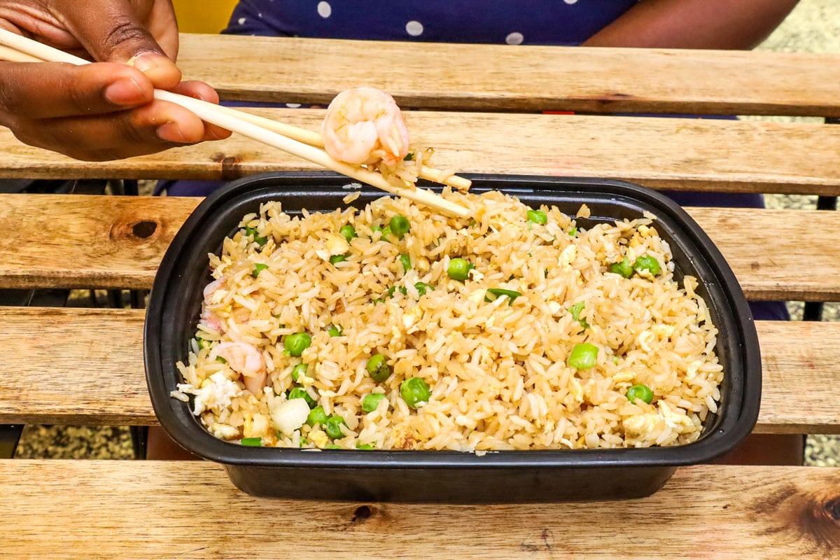 A black container filled with fried rice.