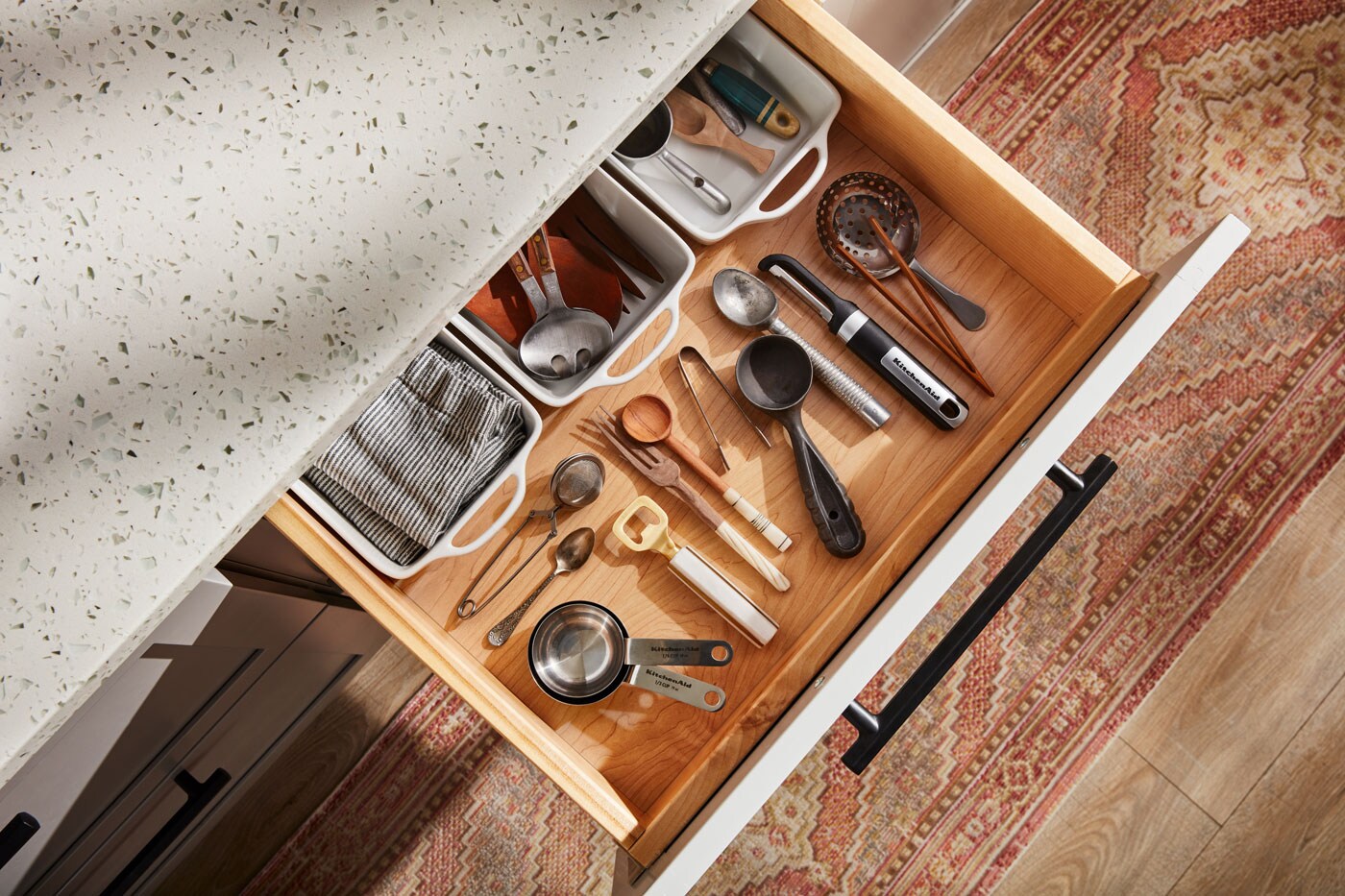 An open kitchen drawer filled with utensils neatly organized.