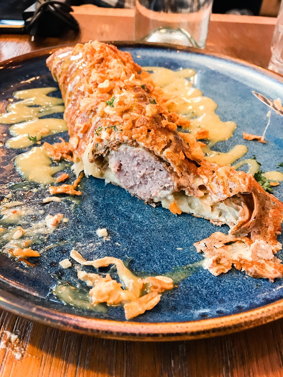 A crispy galette-saucisse drizzled in sauce.