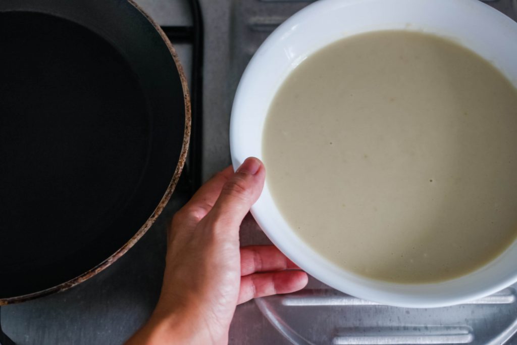 A large white bowl of crepe mixture.