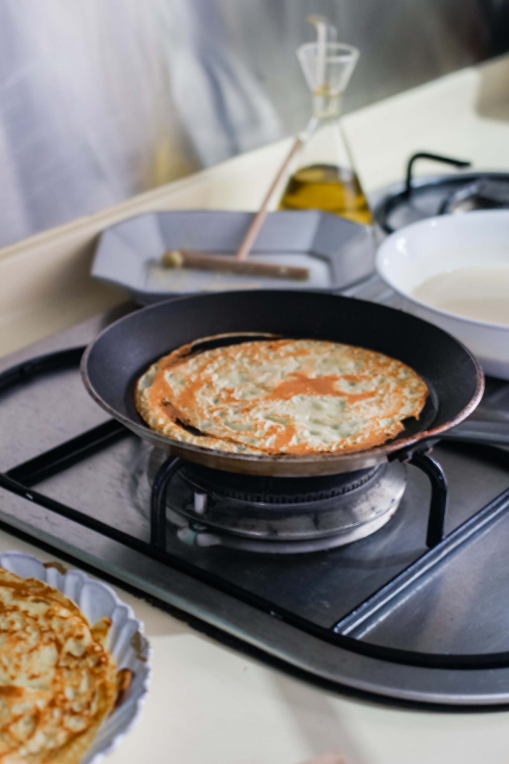 A small pan cooking a crepe.