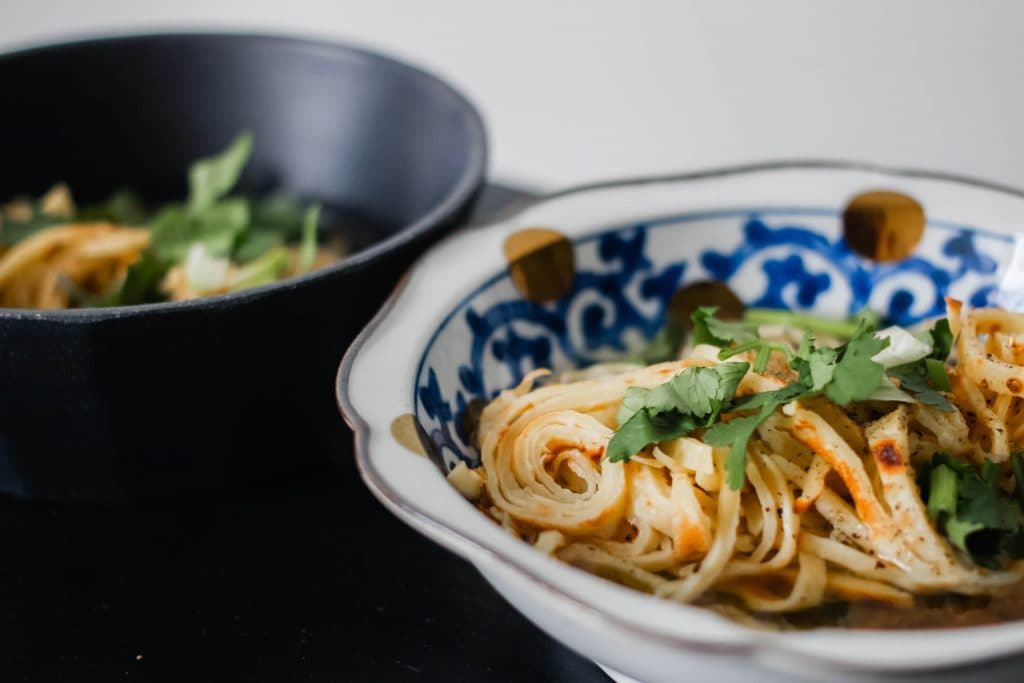 A bowl of crepe noodles in broth.