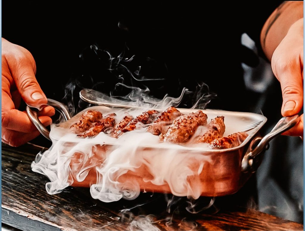 A steaming tray of kebabs.