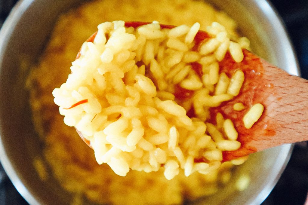 A wooden spoon holding basmati rice.