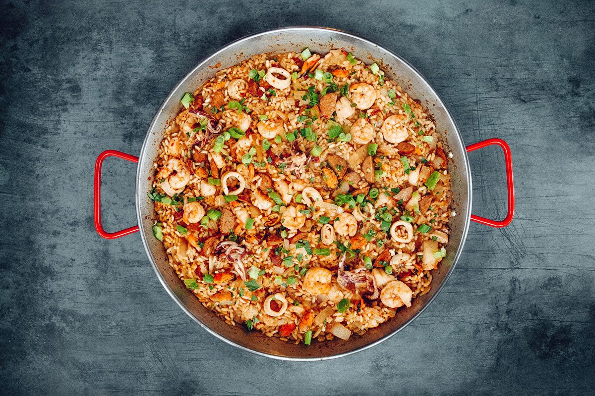 A large red pot filled with shrimp jambalaya.