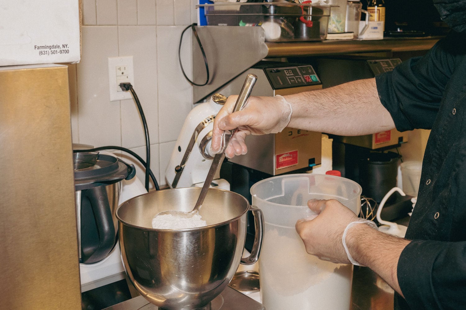 A person pouring flour into a bowl.