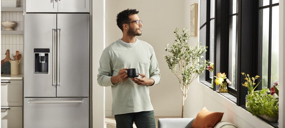 Person looking out the window from a kitchen with a stainless steel French door refrigerator Person looking out the window from a kitchen with a stainless steel French door refrigerator