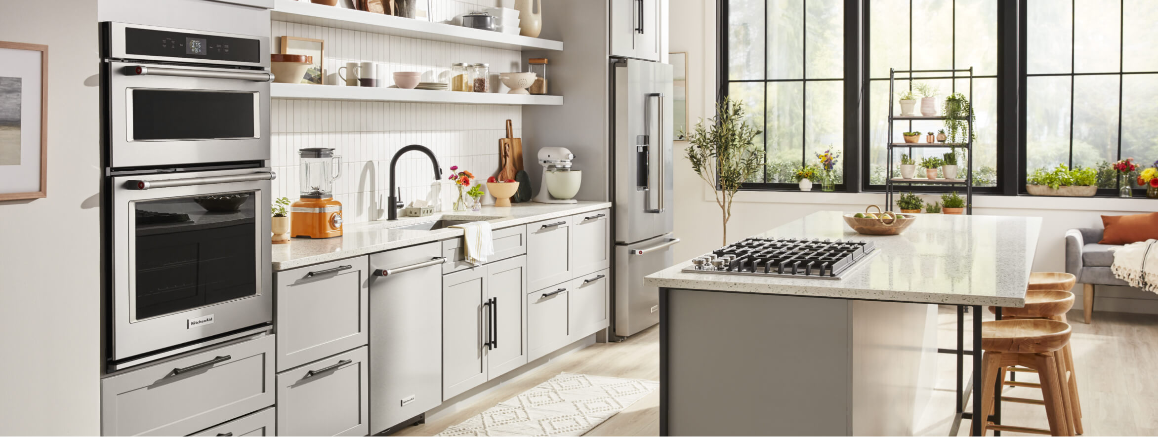 White kitchen with large island and  KitchenAid® appliances.