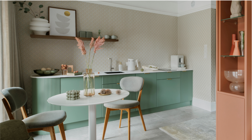 A peach and mint kitchenette and dining room with minimalist furniture.