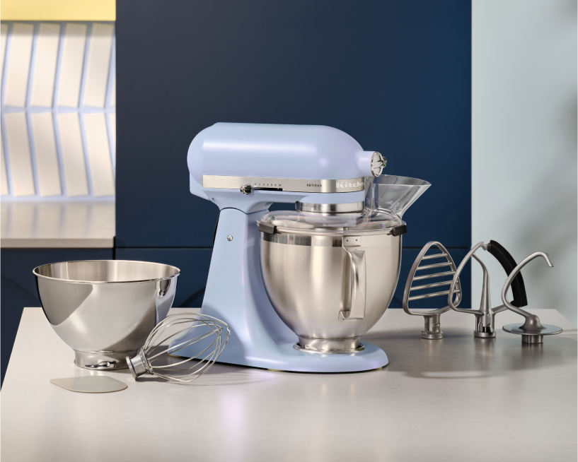 An Artisan® Stand Mixer in Blue Salt surrounded by its accessories.