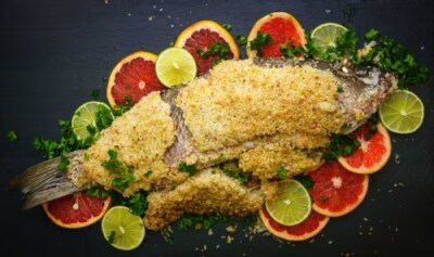 A salt-crusted whole fish on a bed of citrus fruit.