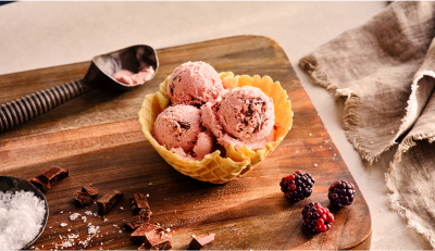 Blackberry chocolate chip ice cream in a waffle cone bowl.