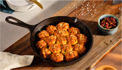 A prepared Garlic-Scallion Pretzel Pull Apart Bread in a cast-iron pan.