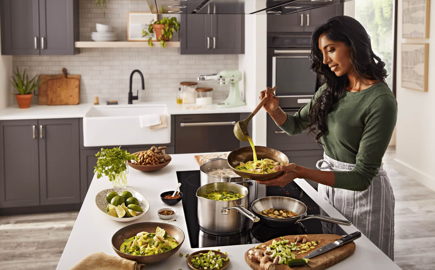 Person cooking on a KitchenAid® induction cooktop