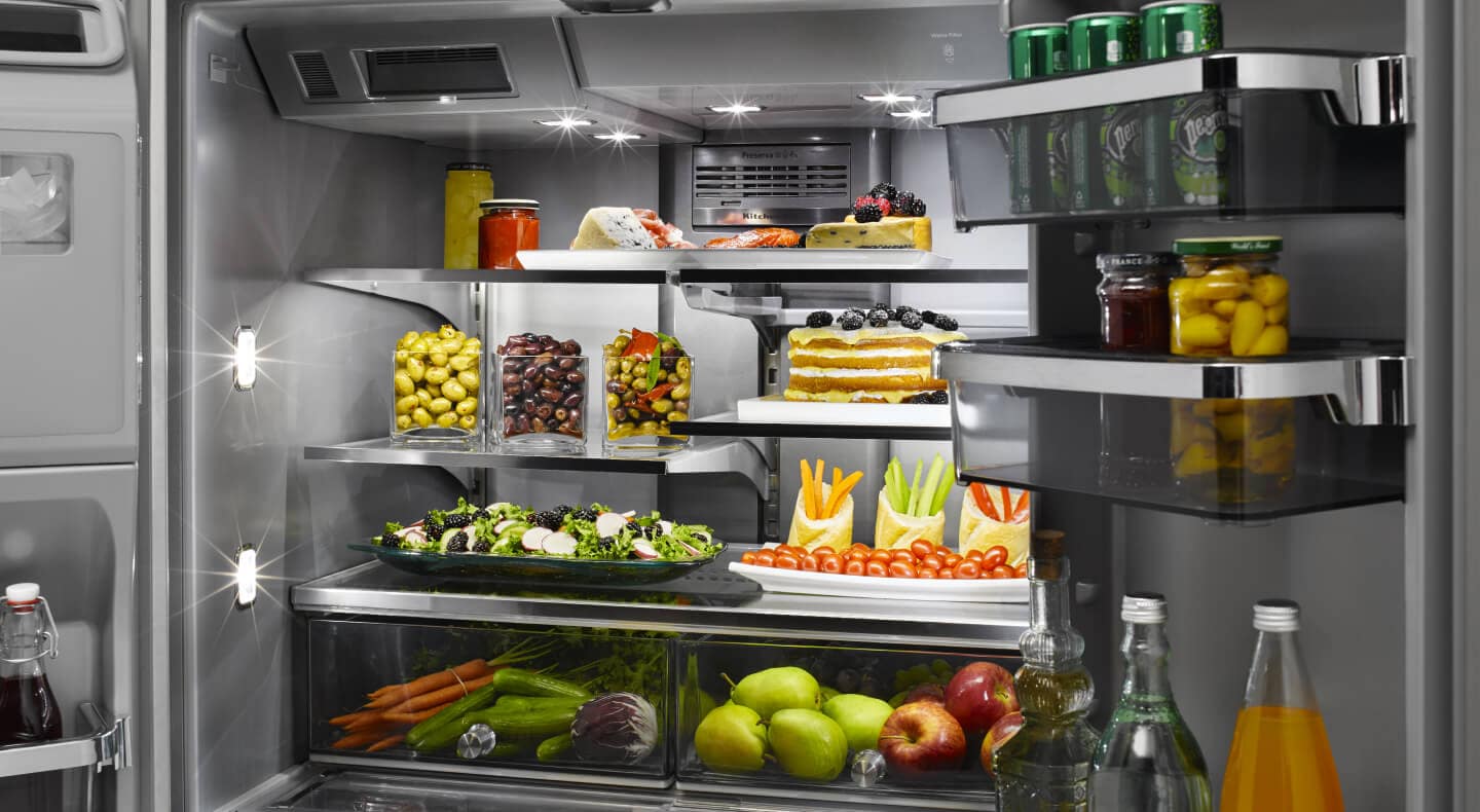 A closeup of a very organized refrigerator with savory items, such as olives, in it