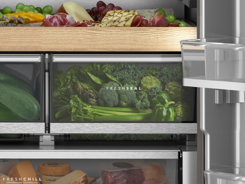 A closeup of refrigerator drawers with green vegetables in them