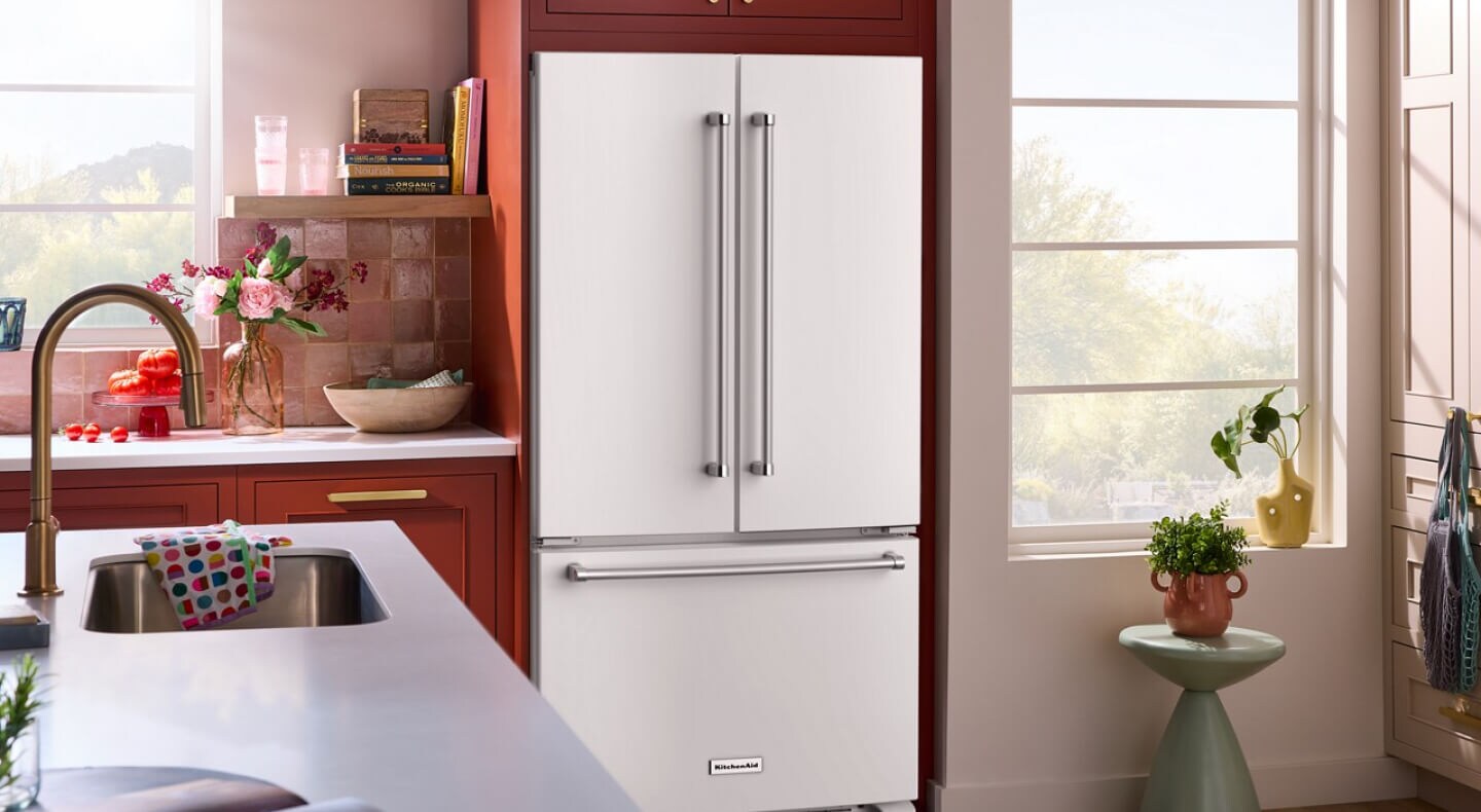 Stainless steel KitchenAid® French door refrigerator in bright orange cabinetry