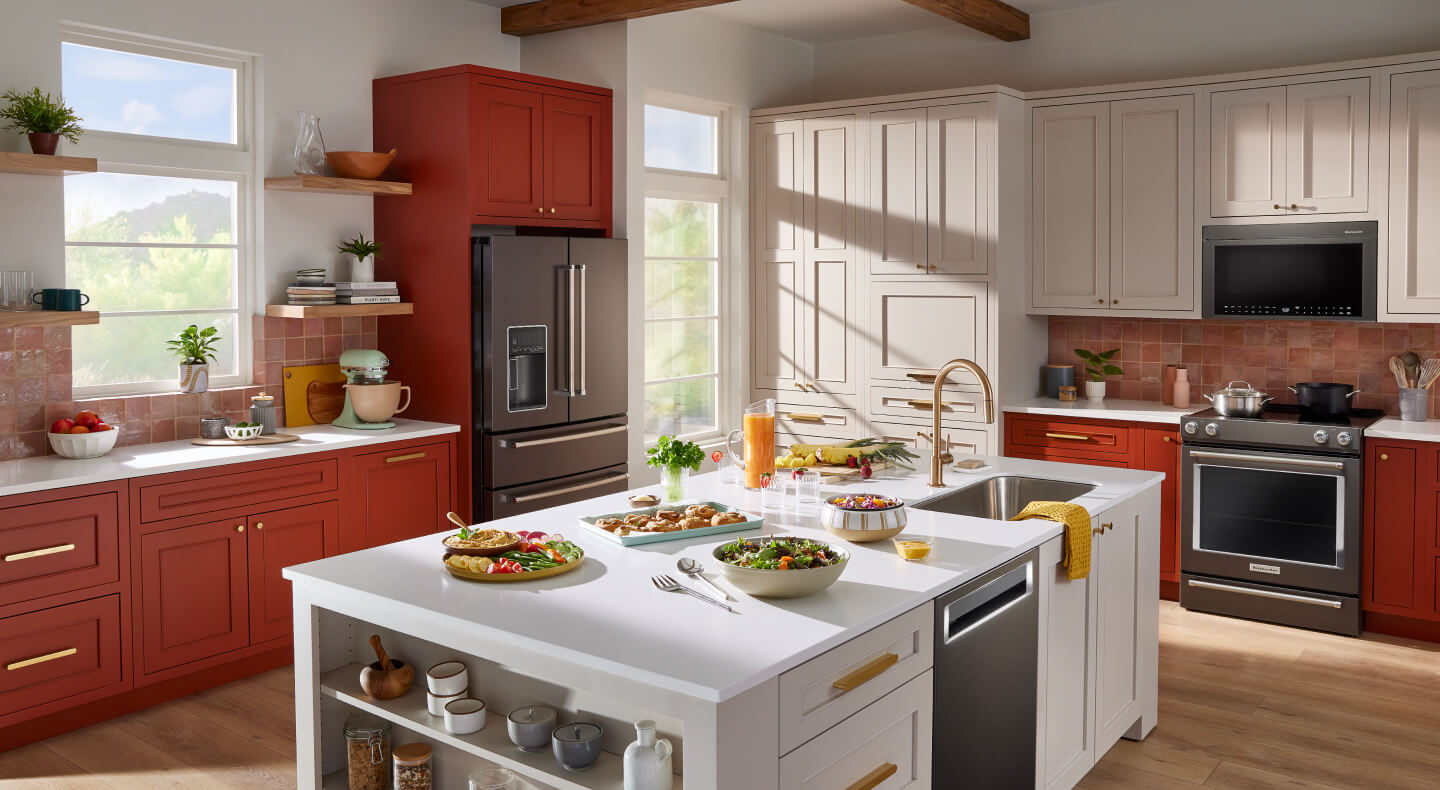 A bright kitchen with red and white cabinets and KitchenAid® Appliances