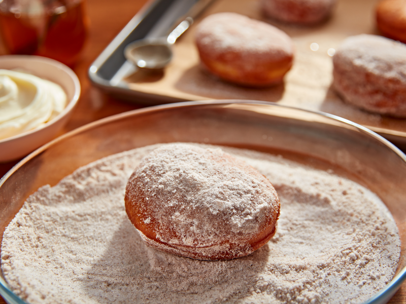 Donut in a bowl of light and dark brown sugar Donut in a bowl of light and dark brown sugar