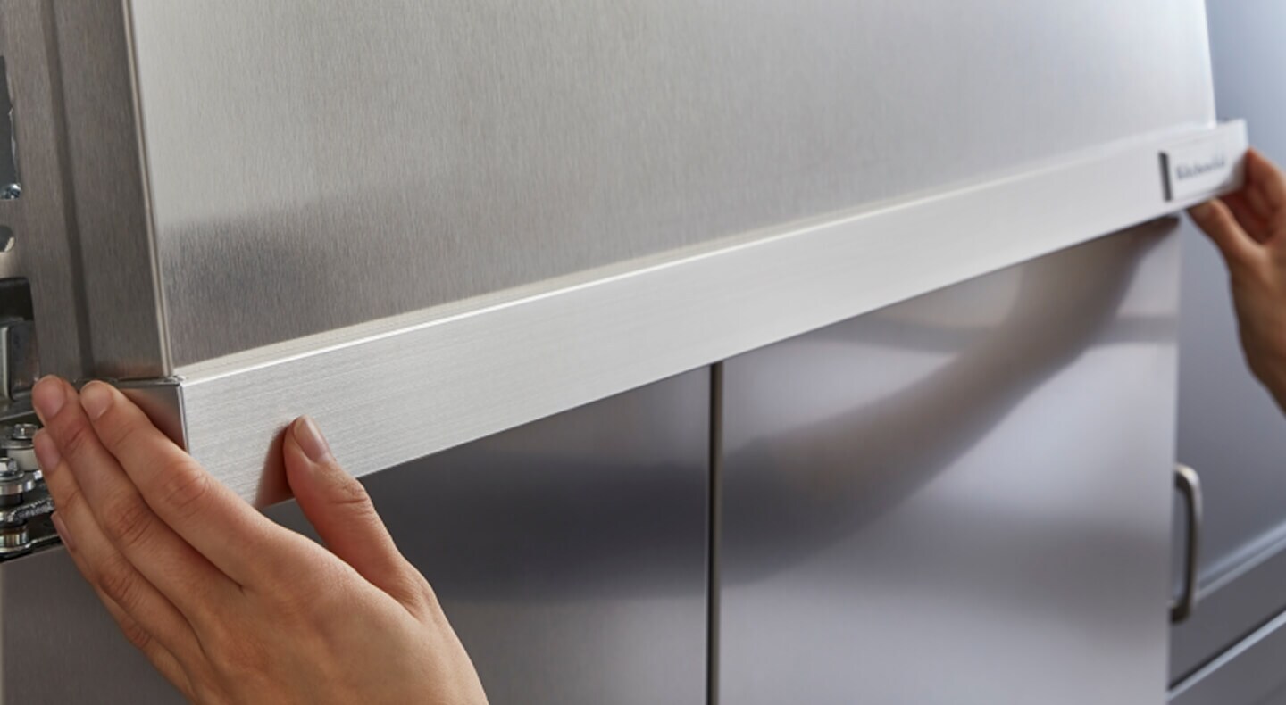 Hands installing parts of a KitchenAid® refrigerator Hands installing parts of a KitchenAid® refrigerator