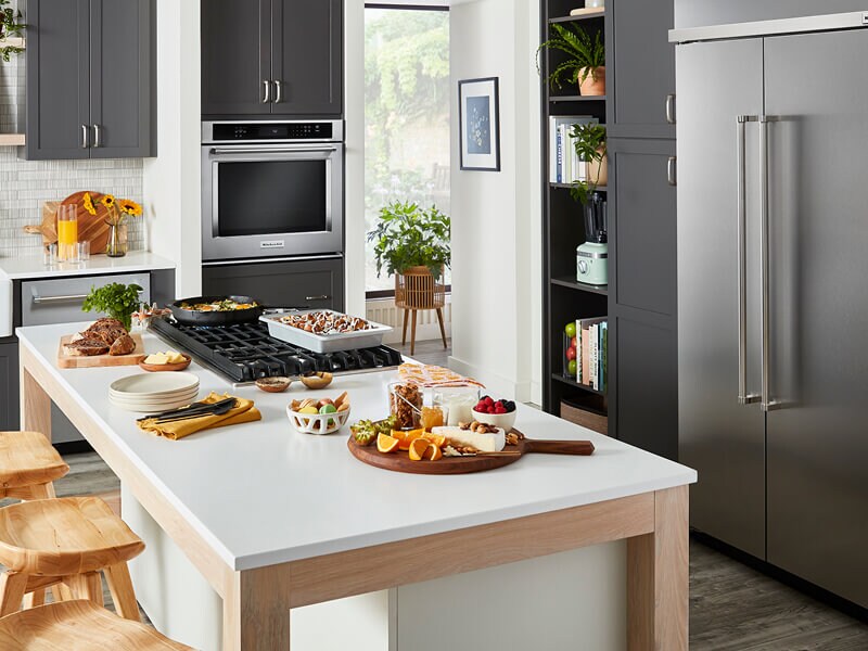 A stylish, modern kitchen filled with KitchenAid® appliances and prepared dishes on the island A stylish, modern kitchen filled with KitchenAid® appliances and prepared dishes on the island