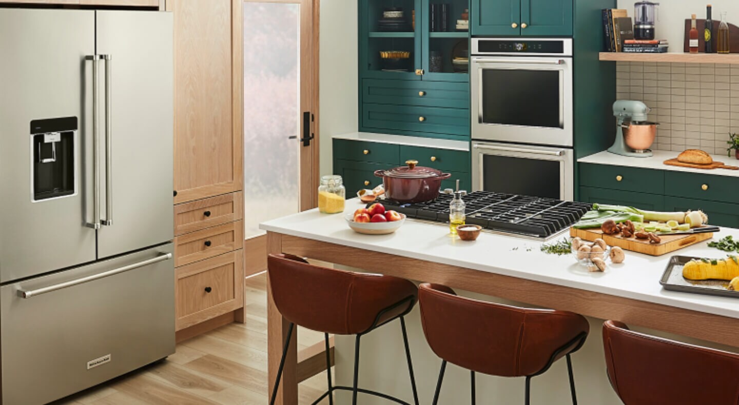 A trendy kitchen with teal cabinetry and a suite of KitchenAid® appliances A trendy kitchen with teal cabinetry and a suite of KitchenAid® appliances