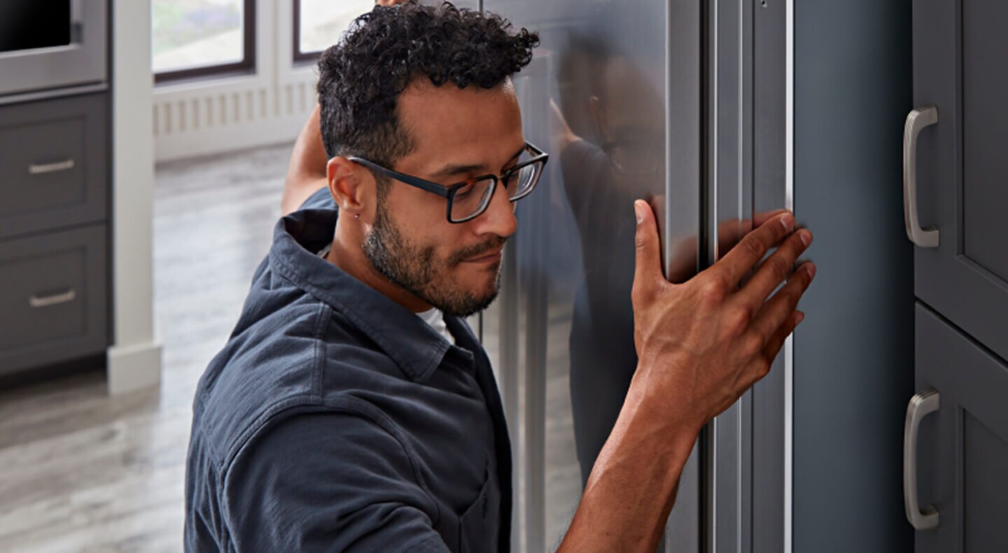 A man installing a KitchenAid® refrigerator A man installing a KitchenAid® refrigerator
