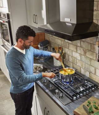 Person cooking on a gas cooktop
