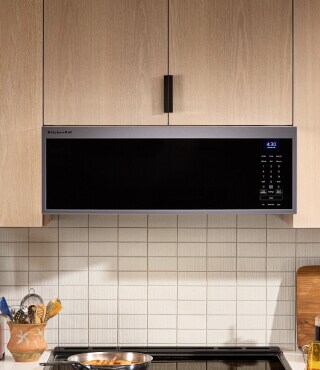 An over-the-range microwave surrounded by brown cabinetry
