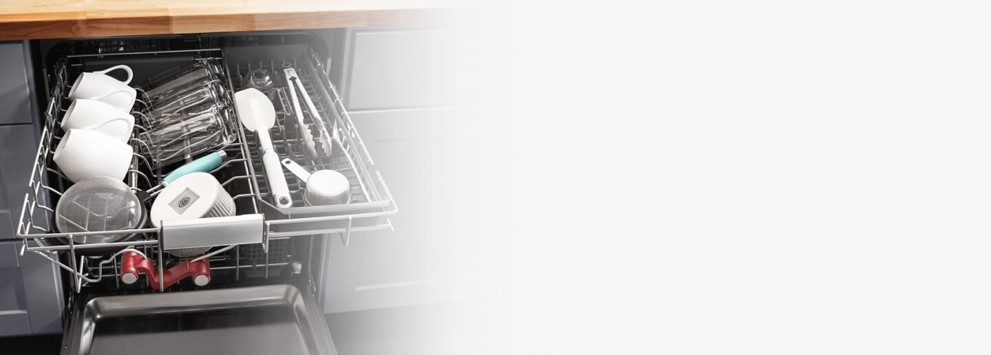 Mugs and cooking utensils in a dishwasher rack