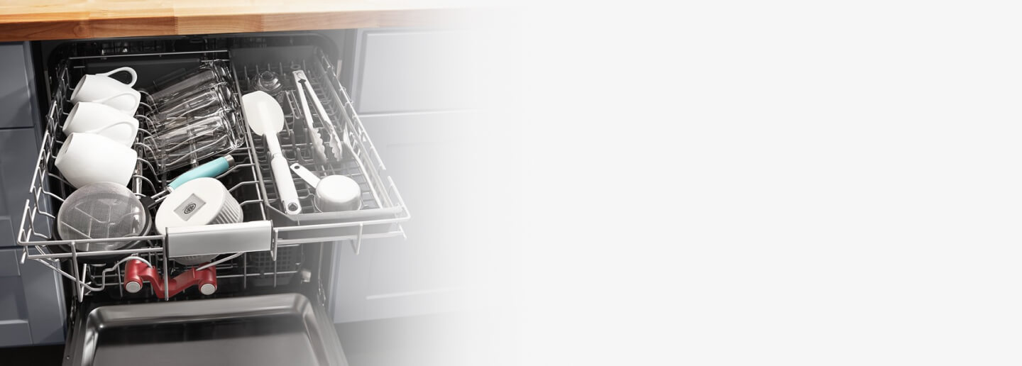 Mugs and cooking utensils in a dishwasher rack