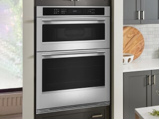 A KitchenAid® wall oven surrounded by gray cabinetry