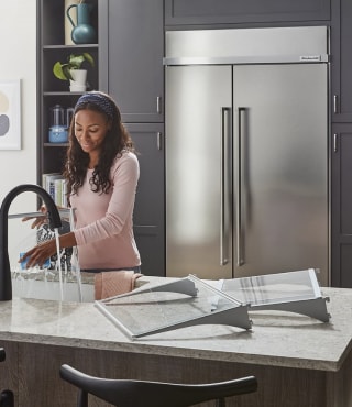 A person cleaning the shelves of their refrigerator