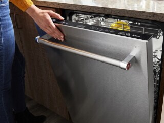 Person closing a dishwasher